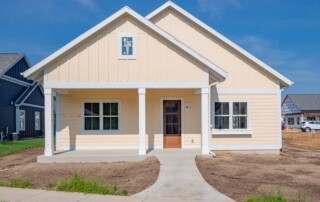 exterior view of yellow home with sidewalk leading to doorway