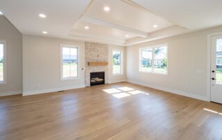 open living area with recessed ceiling and wood floor