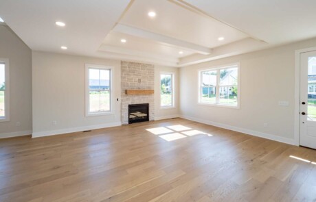 open living area with recessed ceiling and wood floor