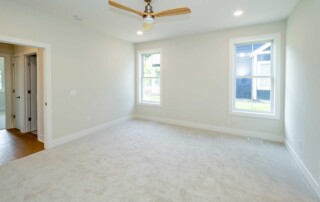 room with two windows and hall leading out
