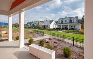 view under porch area showing pillars and other homes