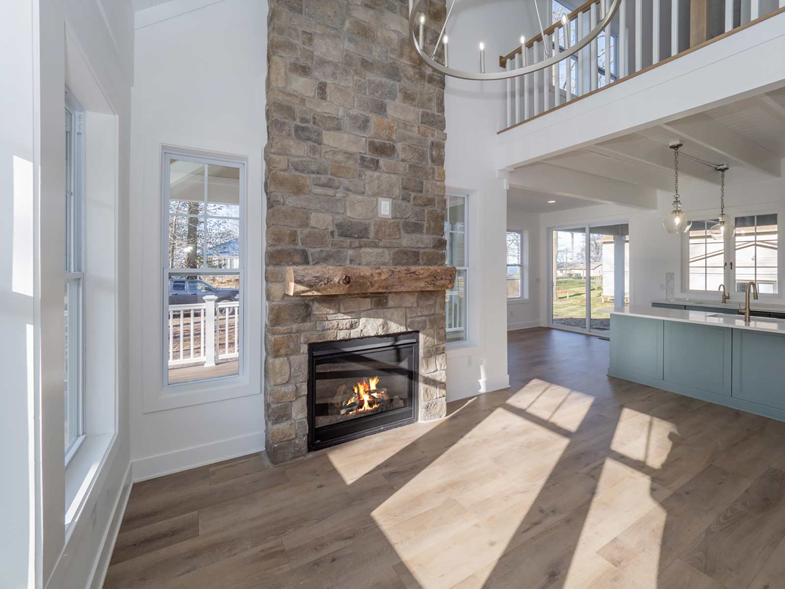 fireplace with tall stone chimney in open living room