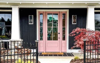 pink front door under porch and five windows