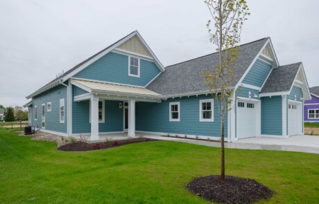 corner view of blue home with yellow accents