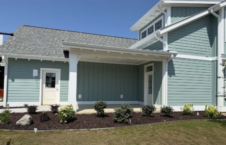 side view of blue-green home with white trim